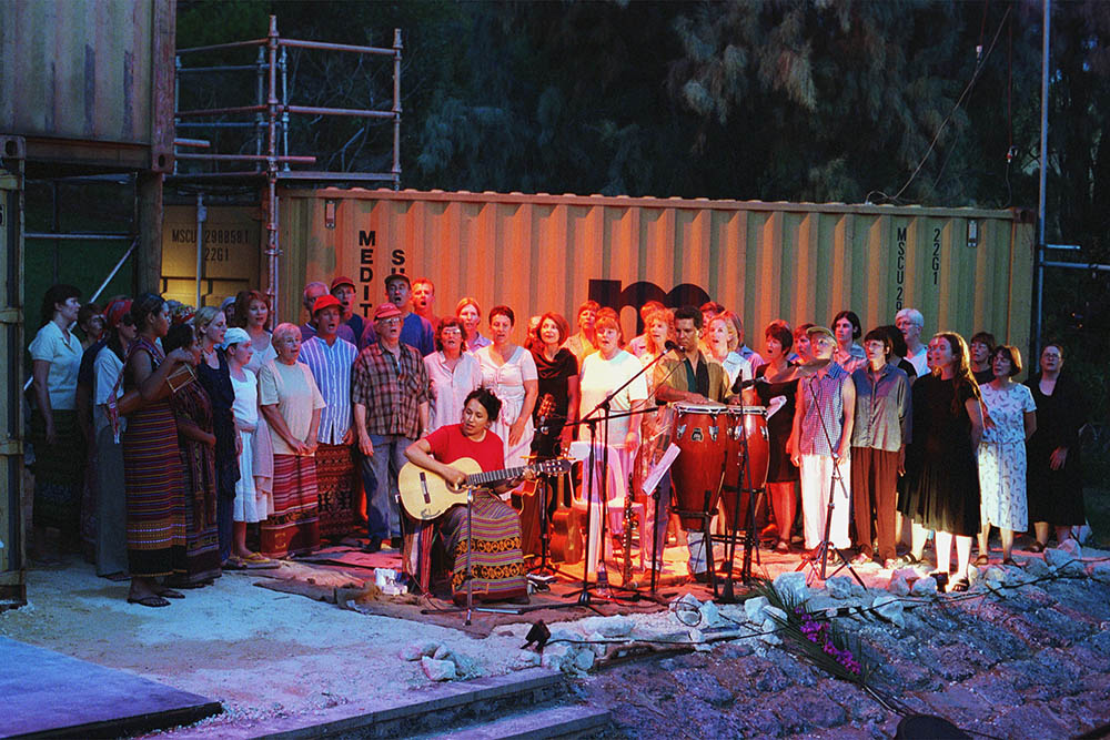 Production still for "Mavis Goes to Timor". The Mavis Goes to Timor Community Choir, with musicians. Photographer: Jon Green